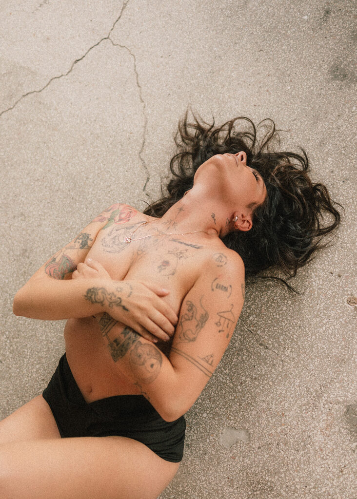 Naga kobieta w studiu industrialnym podczas sesji kobiecej