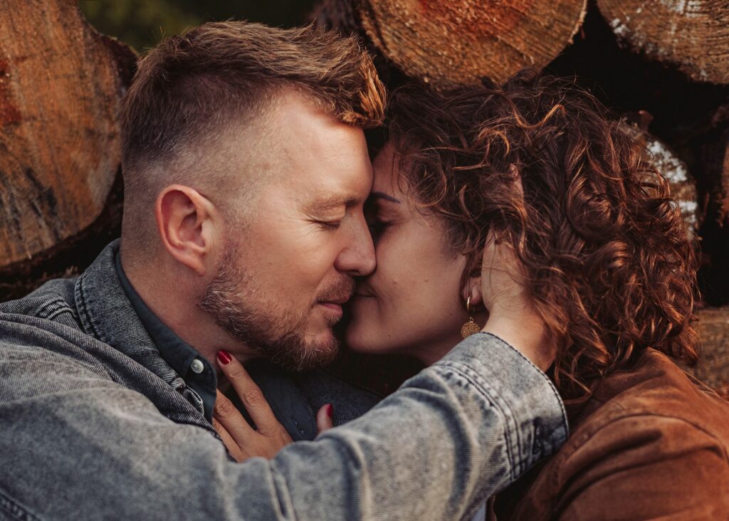 Sesja miłosna pary przy kłodach podczas sesji zdjęciowej