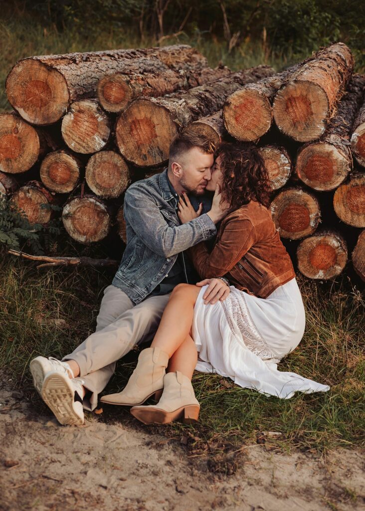 Sesja miłosna pary przy kłodach podczas sesji zdjęciowej